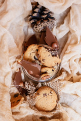 Shortbread chocolate cookies and a glass of milk on a brown background.  Milk chocolate with nuts and cookies.