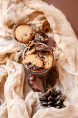 Shortbread chocolate cookies and a glass of milk on a brown background.  Milk chocolate with nuts and cookies.