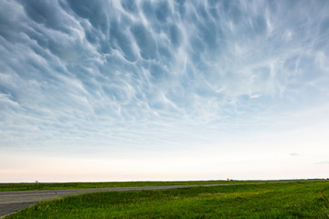 Fototapeta premium Mammatus clouds over green countryside.
