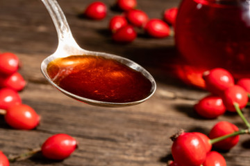 Rosehip seed oil on a spoon with rosehips