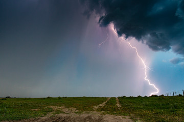 Dramatic bolt of lightning hitting the ground from supercell thunderstorm