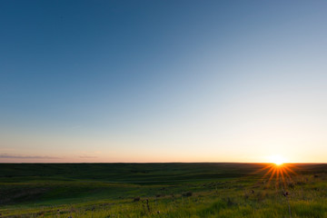 Sun setting on the horizon in Thedford, Nebraska, USA.