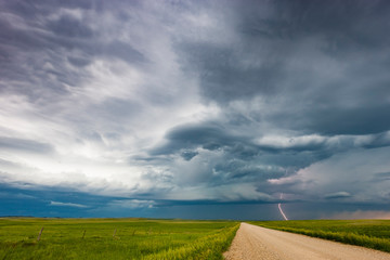 Fototapeta na wymiar Single bolt of lightning hitting the ground from dramatic supercell thunderstorm