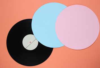 Retro vinyl record on a coral color background with blue pink circles. Retro minimalism. Top view