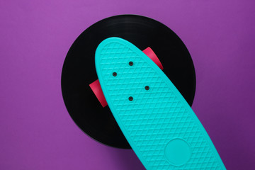 Cruiser board on vinyl record. Purple background. Youth retro style concept. 80s. Top view