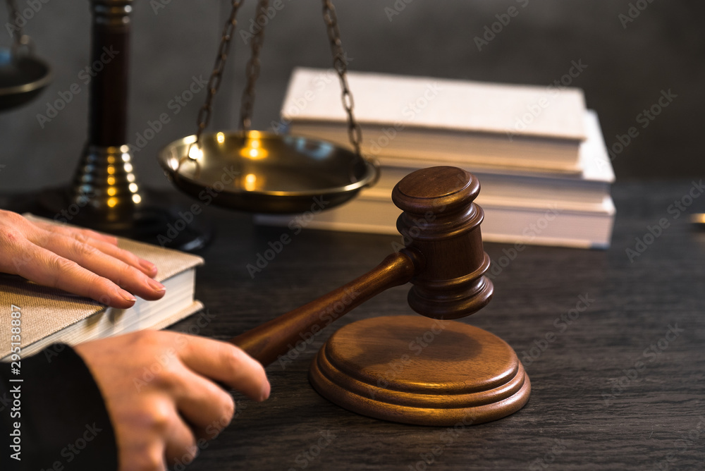 Wall mural Judge working at table with symbols of law and justice on foreground