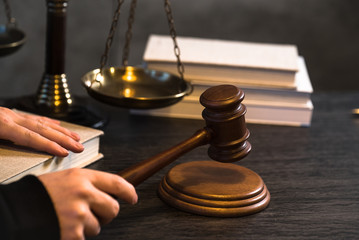 Judge working at table with symbols of law and justice on foreground
