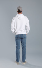 Young man in sweater on grey background. Mock up for design