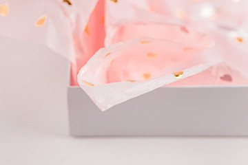Pastel pink gift paper with golden hearts in white present box. Gift wrapping for special occasion. Valentine's Day, Birthday Party, Wedding Anniversary, Mother's Day present. Handmade gift