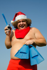 Obraz premium Funny Santa Claus is relaxing on the sea