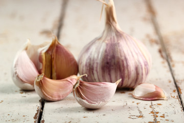 Garlic bulbs and cloves on peeling paint plank table