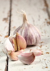 Garlic bulbs and cloves on peeling paint plank table