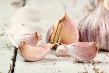 Garlic bulbs and cloves on peeling paint plank table