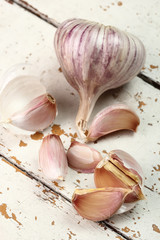 Garlic bulbs and cloves on peeling paint plank table