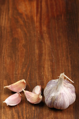 Garlic bulbs and cloves on wooden table, copy space.