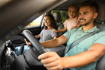 Happy family traveling by car on summer day