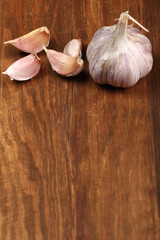 Garlic bulbs and cloves on wooden table, copy space.