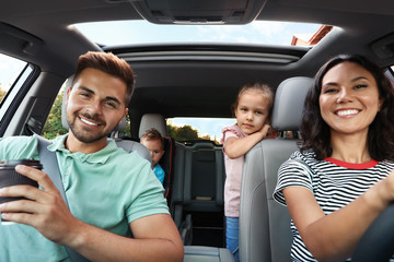 Happy family traveling by car on summer day