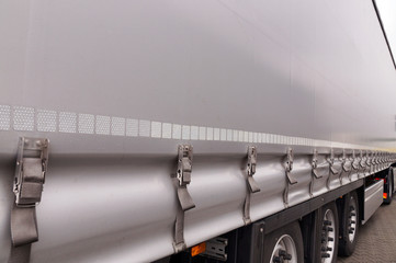 Obraz premium View of the tarpaulin covering the semi-trailer of the truck. Truck transport.