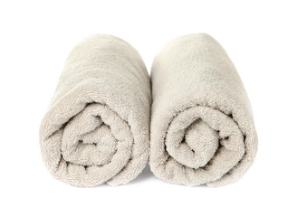 Rolled clean beige towels on white background