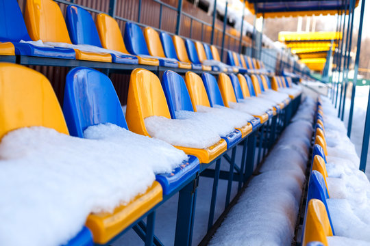 colored seats snow covered in winter snowy stadium. Snow covered tribune