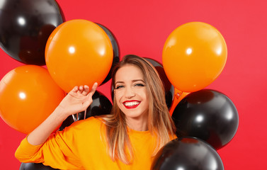 Beautiful woman with balloons on red background. Halloween party