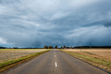 storm clouds over asphalt road in perspective