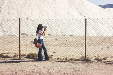 Filmmaker filming through a wire fence