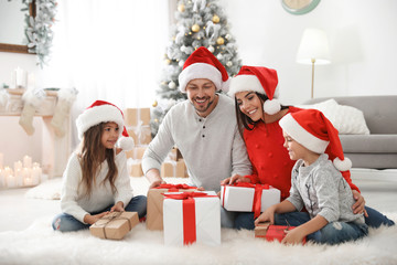 Happy family with children and Christmas gifts on floor at home
