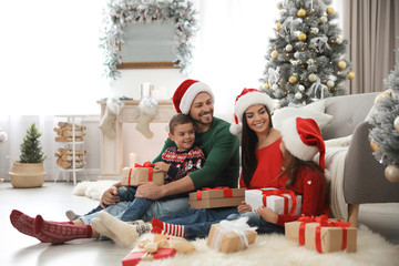 Happy family with Christmas gifts on floor at home