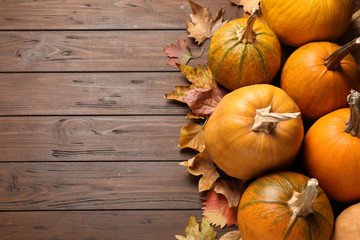 Flat lay composition with different ripe pumpkins on wooden background, space for text. Holiday...