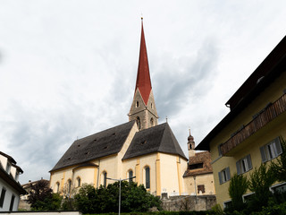 Fototapeta na wymiar The church of Schlanders on a cloudy day in summer