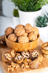 Whole walnuts in bowl. Dried figs with walnuts on wooden background.