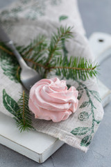 Homemade pink marshmallow on fork with Christmas fir-tree branches