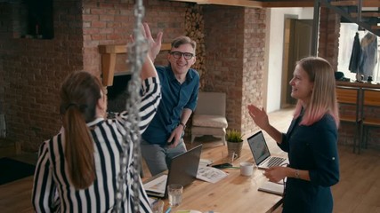 Happy Teamwork Celebrating Success by Hi Five and Clapping. Casual Diverse Team Applauding to Asian Female Leader or Manager in Startup Loft Office. 4K Gimbal Orbit Corporate Shot in Slow Motion