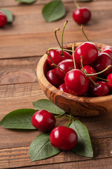 ripe cherries in a wooden bowl on the background