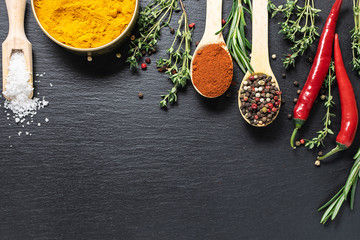 Different spices, herbs and vegetables on black stone background with copy space for your text....