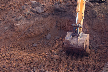 Industrial background. A crawler excavator bucket carries out earthwork at a construction site.