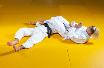 Martial arts. Sparing Portners. Sport man and woman in white kimono train judo throws and captures...