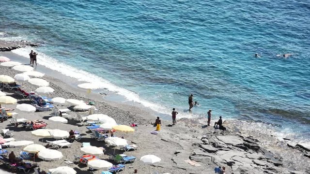 Aerial view of beach in Mahmutlar Alanya on the Turkish Mediterranean Coast. Tourists and locals enjoy the beach with umbrellas and sunbeds and swim in the turquoise ocean.
