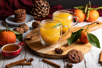 Two glass cups with homemade healthy sea-​​buckthorn tea, selective focus