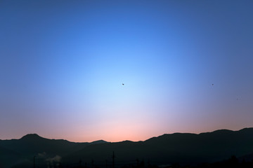 長野県の山並みと朝焼けの空と鳥（Sunrise sky and birds flying in the sky）