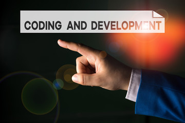 Writing note showing Coding And Development. Business concept for Programming Building simple assembly Programs Isolated hand pointing with finger. Business concept pointing finger