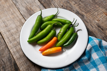 Raw serrano peppers on wooden background