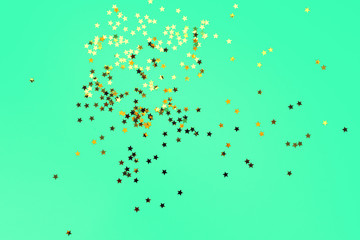 Golden decorative stars on mint background. Holiday and festive concept