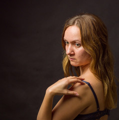 Portrait of young woman, no make up, low key, brown dark hair, no retouch making expressions