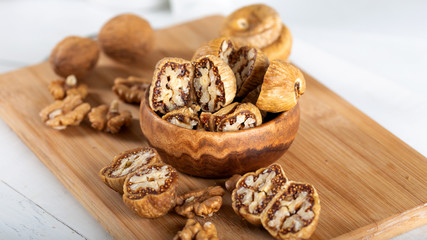 Dried figs with walnuts in wooden bowl.
