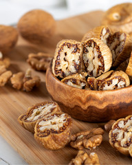 Dried figs with walnuts in wooden bowl.