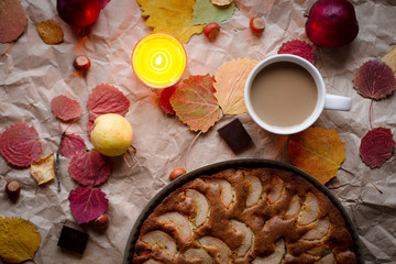 cozy evening with a Cup of cocoa with pear cake, autumn decorations made of natural fallen autumn leaves by candlelight