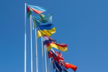 Flags of different countries on the background of the blue sky